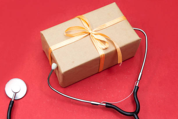istock Medical stethoscope with red gold gift box on white background. 1126209536