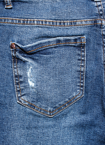 Rear pocket of torn worn jeans
