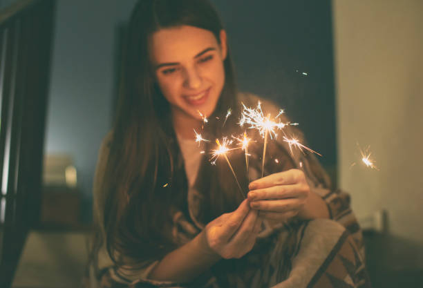 istock young woman sitting on stairs  and lights fireworks 1126217841