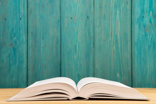 Open book on the desk over wooden background