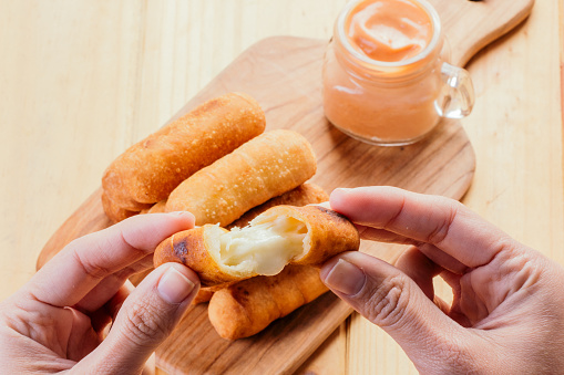 Woman's hands holding an appetizing and delicious tequeño typical snack of venezuelan food