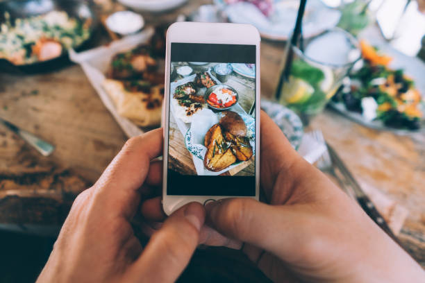 Sharing food Taking Photo with Smartphone of tasty meal  for social media before eating it personal perspective photos stock pictures, royalty-free photos & images