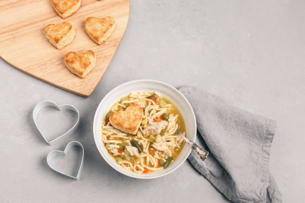 istock Heart-Shaped Biscuits with Homemade Chicken Soup on Gray Background 1126237410