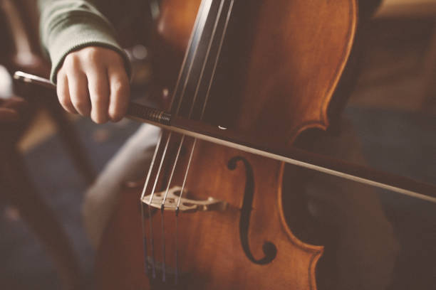 istock A little boy is practicing on his cello with his teacher 1126240416