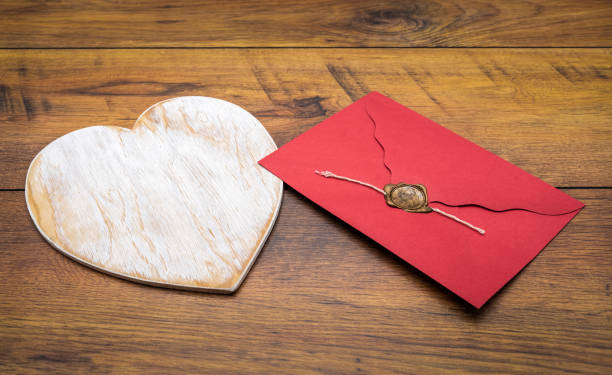 istock Retro classic Valentine's Day cad, large white painted wooden hart, isolated, red envelope with wax seal, on vintage oak panels - front view 1126241700