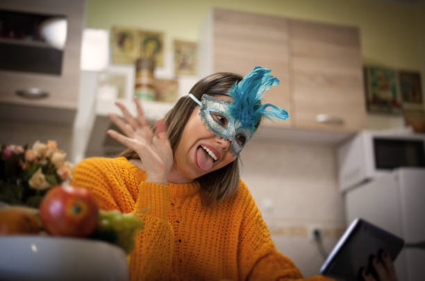 Funny faces. Woman using digital tablet making video call. carnival mask women party stock pictures, royalty-free photos & images