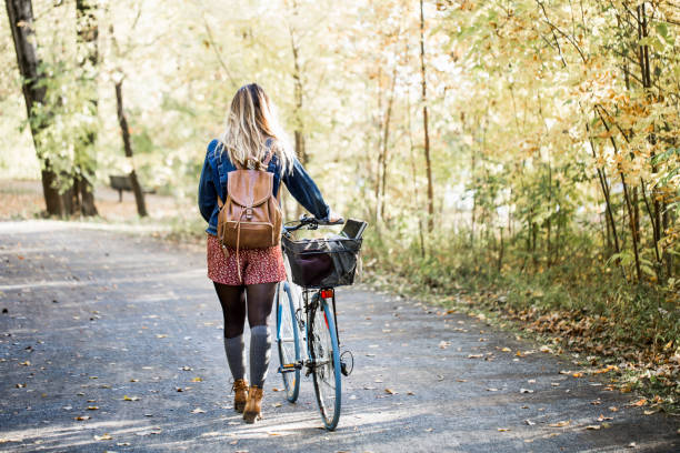 portait красивой молодой женщины во время осеннего сезона - walk cycle стоковые фото и изображе�ния