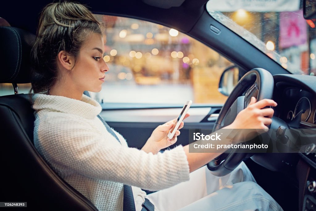 Jong meisje is SMS in de file - Royalty-free Rijden - Een motorvoertuig besturen Stockfoto