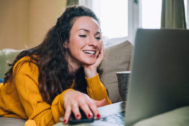 istock Mother and daughter using laptop on sofa 1126248890
