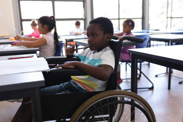 istock Thoughtful disable schoolboy looking away at desk in classroom 1126252037