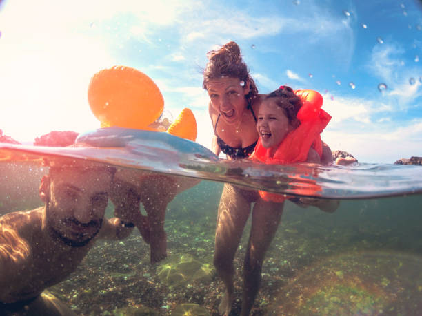 mor och far undervisning döttrarna simma - baby swim under water bildbanksfoton och bilder