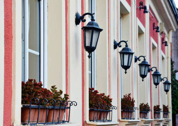 Retro styled facade with lanterns and flowerpots on the windows