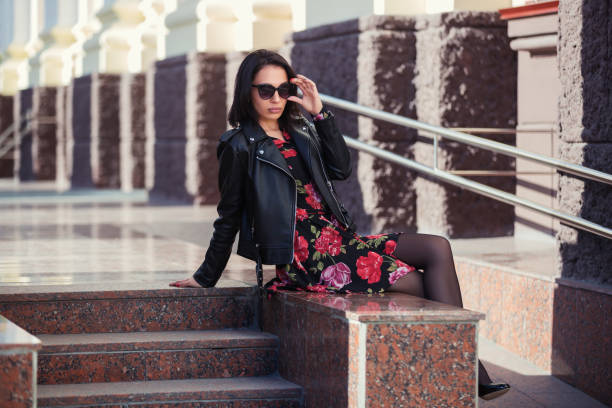 Happy young fashion woman in leather jacket and sunglasses stock photo
