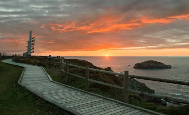 Foghorn and wooden walkway near lighthouse Peñas Cape on a beautiful sunset Coast of Asturias, Spain