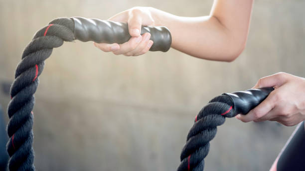 istock Athletic woman doing gym battle rope workout 1126258814