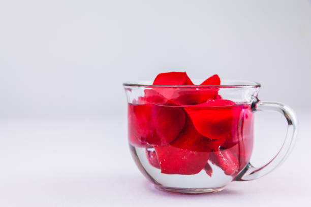 Red Rose Petals In A Glass Of Water stock photo