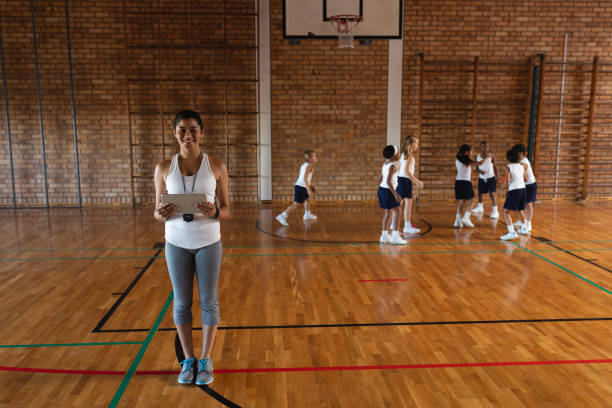istock Smiling female basketball coach with digital tablet looking at camera 1126264283