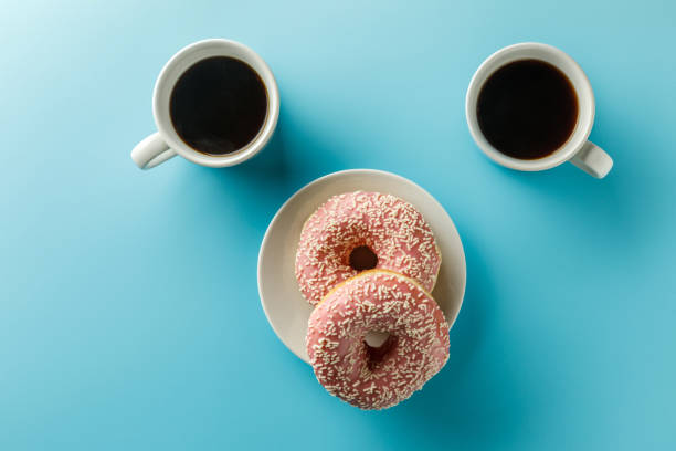 istock two cups of coffee and donuts. Copy space. Top view 1126266391