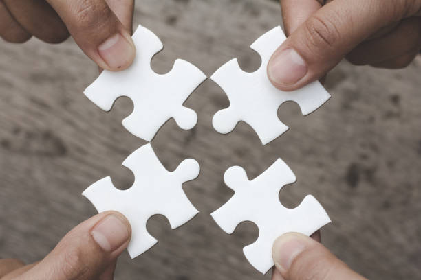 istock Hands of diverse people assembling jigsaw puzzle, Youth team put pieces together searching for right match, help support in teamwork to find common solution concept, top close up view 1126268643