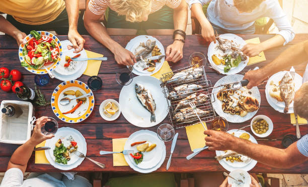 大きな miltigeneration プロセスで家族の夕食。トップ ビュー食品と手でテーブルの上の垂直方向の画像 - meeting food nature foods and drinks ストックフォトと画像