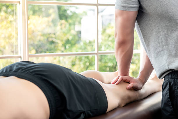 piernas dando terapeuta masculino masaje paciente atleta en clínica - massaging men swedish culture male fotografías e imágenes de stock