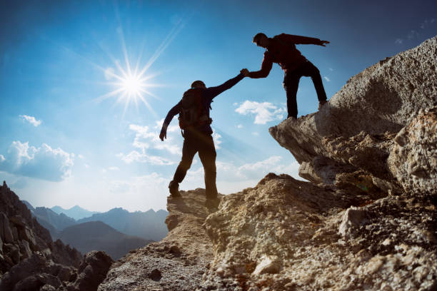 istock Friends climb a mountain together 1126277364