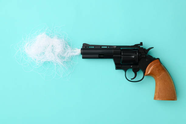 istock Black revolver with gun smoke on light blue background 1126287567