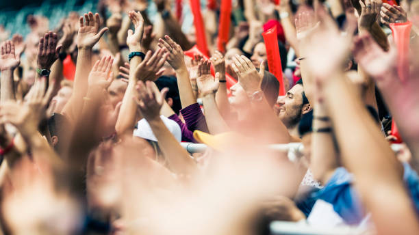 istock Crowd cheering for their team with arms raised 1126295330