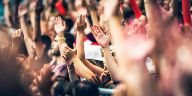 istock Crowd cheering for their team with arms raised 1126295334