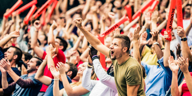 istock Crowd cheering for their team with arms raised 1126295337