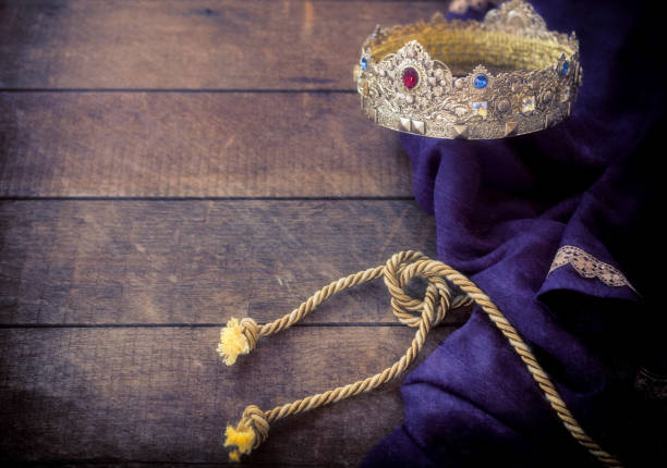 Easter Jesus Gold Kings Crown lying on a Royal Purple Robe against a Rustic Wood Background Easter - Jesus jeweled gold kings crown, royal purple robe against a wooden background with textured effect. Selective focus ceremonial robe stock pictures, royalty-free photos & images