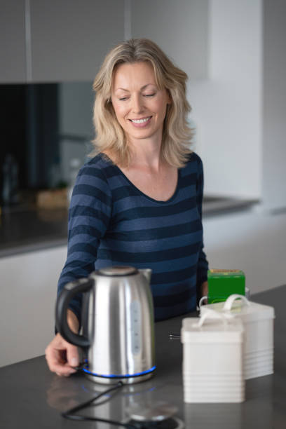istock Woman making a cup of tea at home 1126300350