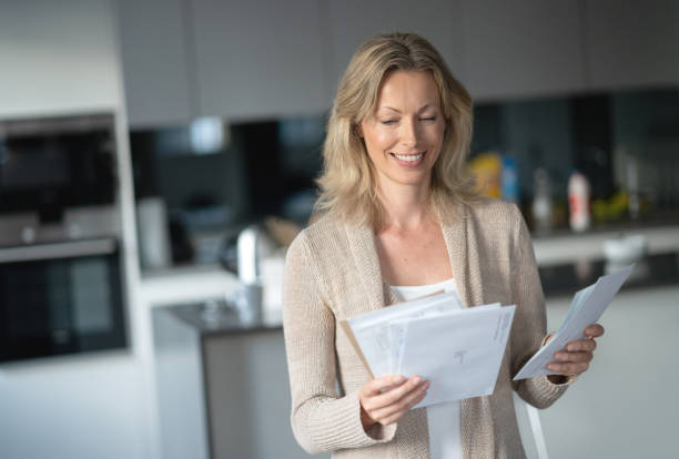 istock Happy woman at home checking her mail 1126300361