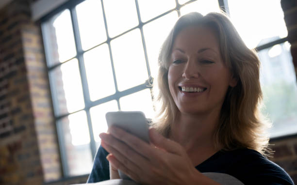 istock Woman relaxing at home and using app on her mobile phone 1126300371