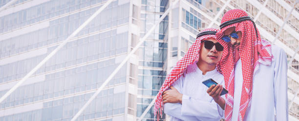 istock Two Arab businessmen messaging on a mobile phone in city 1126303441
