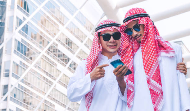 istock Two Arab businessmen messaging on a mobile phone in city 1126303453