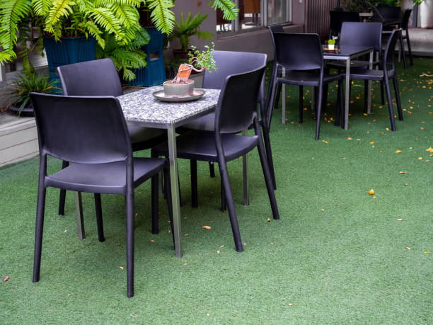 istock Black Chairs and marble table on artificial green grass 1126307205