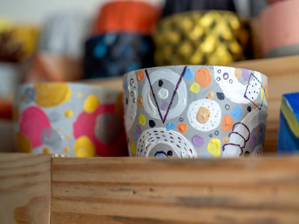 Colorful geometric planters on wooden shelf. modern beautiful painted concrete planters decoration.