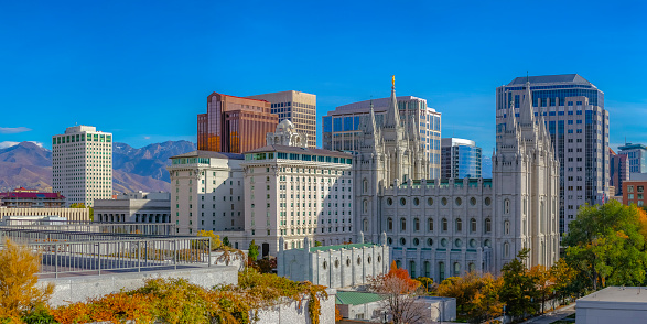Towering buildings against mountain and vivid sky. Beautiful towering buildings in Salt Lake City with a vivid blue sky and mountain in the background. Scenic downtown in Utah on a bright sunny day.