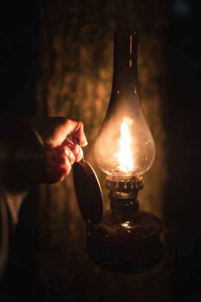 A Burning Kerosene Lamp On Wood Board Background