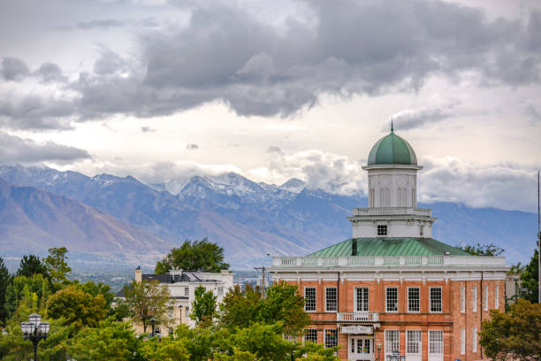 istock Buildings and snow capped mountain under clouds 1126324506