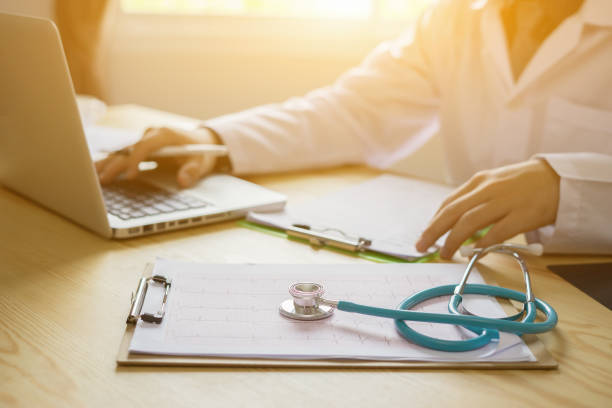 Stethoscope with clipboard and Laptop on desk,Doctor working in hospital writing a prescription, Healthcare and medical concept,test results in background,vintage color,selective focus Stethoscope with clipboard and Laptop on desk,Doctor working in hospital writing a prescription, Healthcare and medical concept,test results in background,vintage color,selective focus emergency response workplace stock pictures, royalty-free photos & images