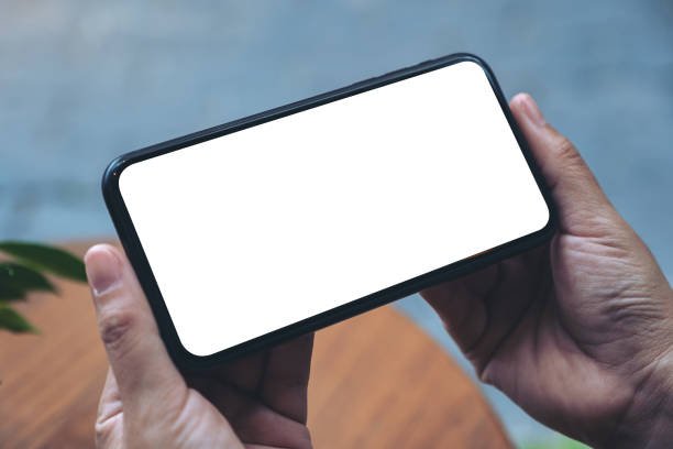 istock hands holding black mobile phone with blank white desktop screen 1126329872