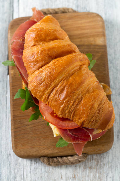 istock croissants with arugula, cheese and tomato on wooden surface 1126331467