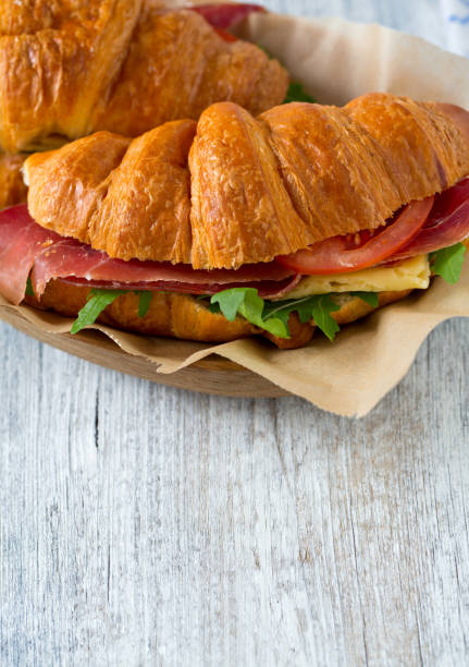 istock croissants with arugula, cheese and tomato on wooden surface 1126331646