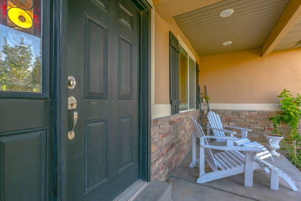 istock Green front door and porch with white chairs 1126332282