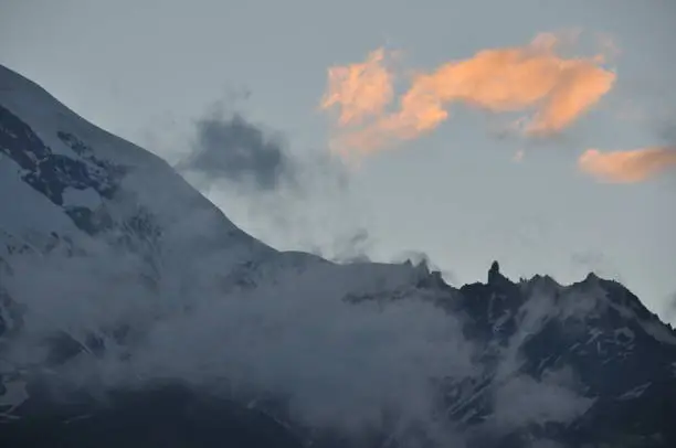 Photo of Snow-capped mountains Kazbek at dawn and the valley below where there is a church siete Trinity. Georgia.