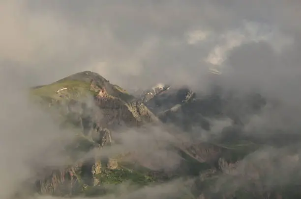 Photo of Snow-capped mountains Kazbek at dawn and the valley below where there is a church siete Trinity. Georgia.