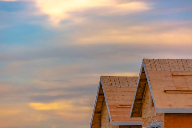 Unfinished roofs against glowing sky in Daybreak. Exterior view of unfinished roofs with a glowing cloudy sky in the background. Construction of new homes in scenic Daybreak, Utah community.