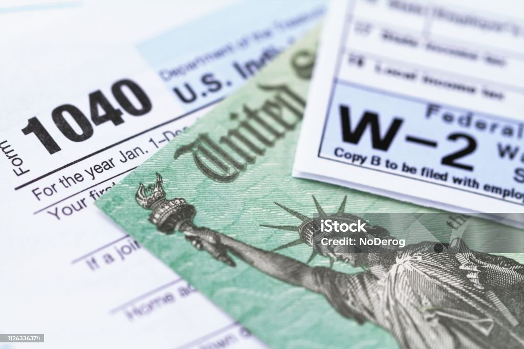 IRS tax forms with tax refund check 1040 income tax form and w-2 wage statement with a federal Treasury refund check. Closeup with selective focusing. Tax Form Stock Photo